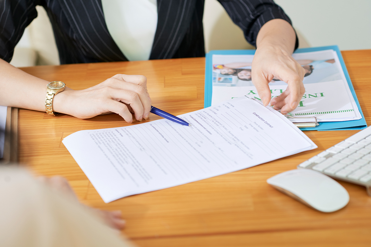 blue pen pointing at the loan terms and conditions paperwork